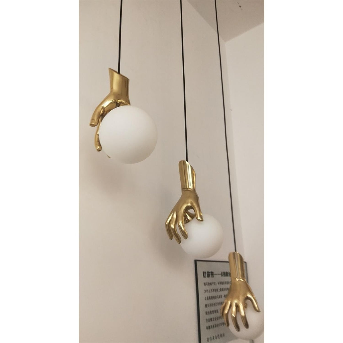Hand Holding Globe Pendant Light - Sculptural Brass Hand & White Glass Orb Pendant